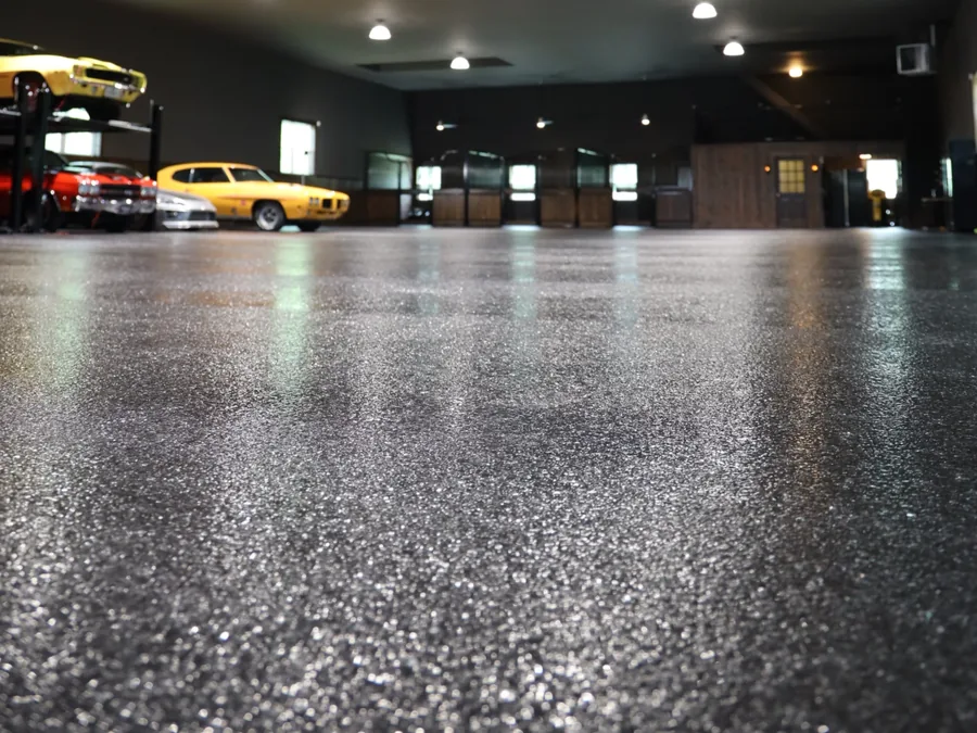 Dark flake floor coating in a showroom with classic cars