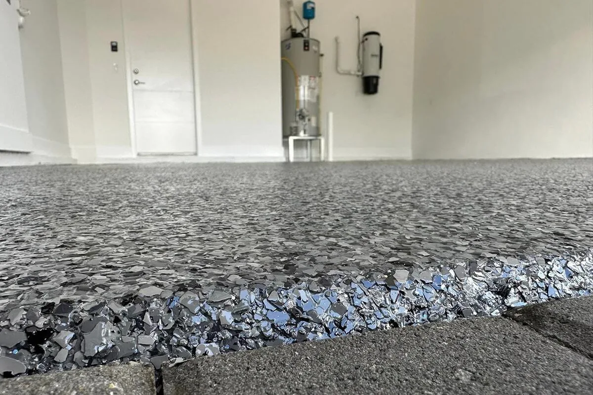 Glossy gray flake coating on a garage floor edge