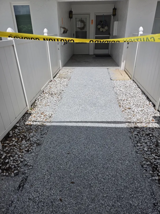 Epoxy flake walkway installation in progress — coated section beside prepped concrete